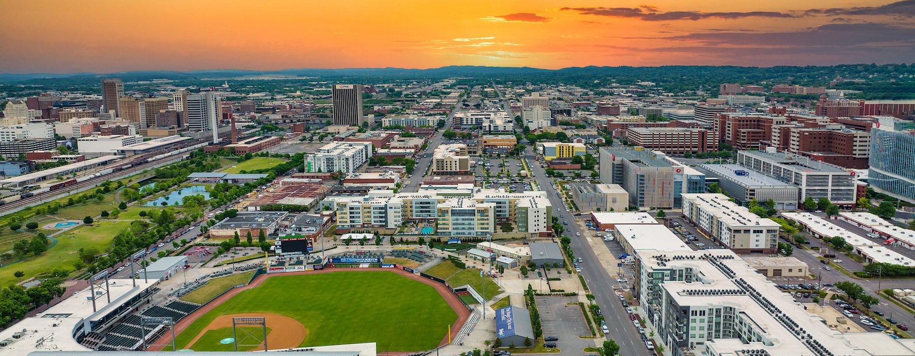 an aerial view of a city with a baseball stadium