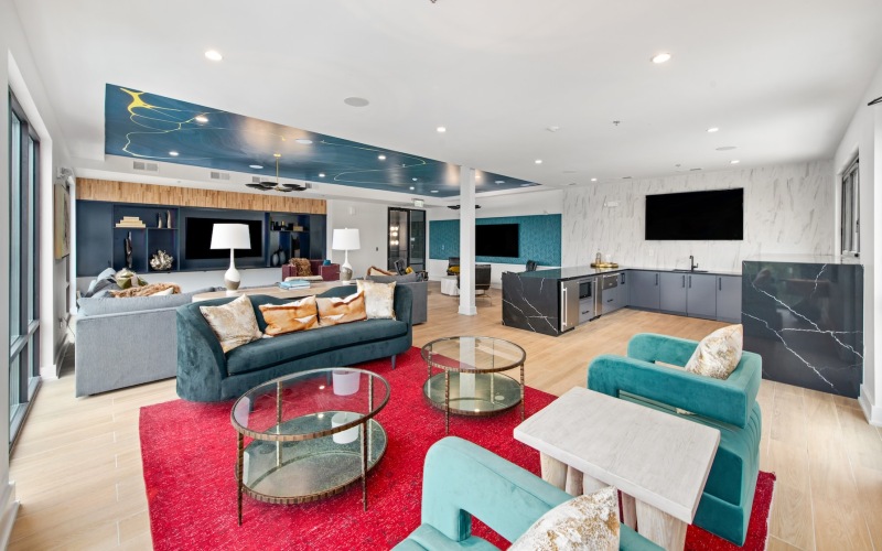 a clubroom with a couch, tables and chairs